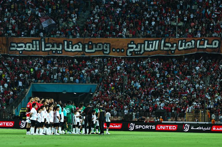 Egypt national team fans hold up a banner reading ''History began here, glory begins here'' during the 2026 FIFA World Cup qualifier between Egypt and Guinea-Bissau at Cairo International Stadium in Cairo, Egypt, on October 12, 2025. (Photo by Ahmed Mosaad/NurPhoto via Getty Images)