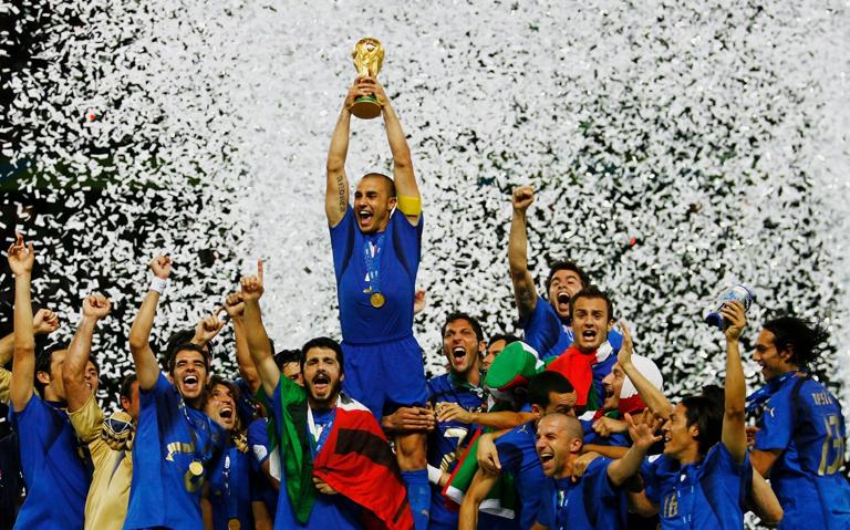 BERLIN - JULY 09:  The Italian players celebrate as Fabio Cannavaro of Italy lifts the World Cup trophy aloft following victory in a penalty shootout at the end of the FIFA World Cup Germany 2006 Final match between Italy and France at the Olympic Stadium on July 9, 2006 in Berlin, Germany.  (Photo by Shaun Botterill/Getty Images)